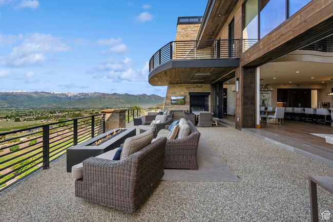 View of patio with a balcony, an outdoor living space with a fire pit, and a mountain view | Image 20