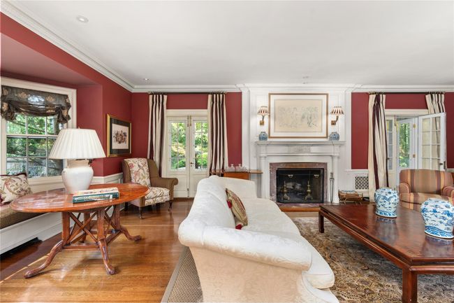 Living room featuring wood finished floors, ornamental molding, a premium fireplace, and a wainscoted wall | Image 4