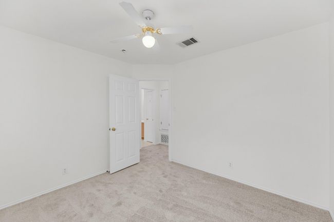 Spare room featuring visible vents, a ceiling fan, baseboards, and light carpet | Image 31
