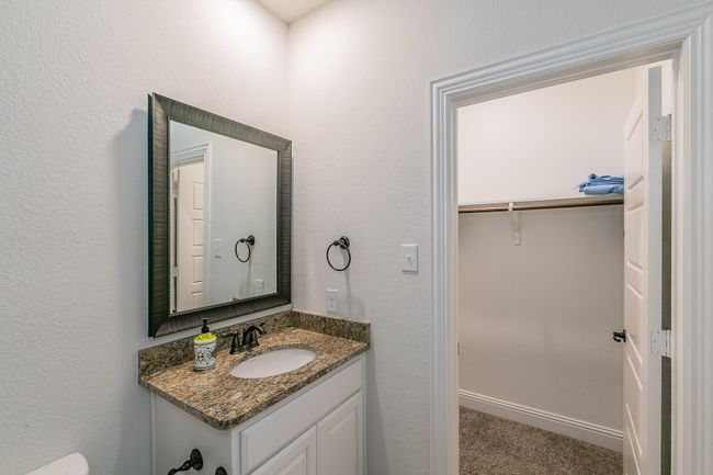 Bathroom featuring a spacious closet, vanity, and baseboards | Image 6