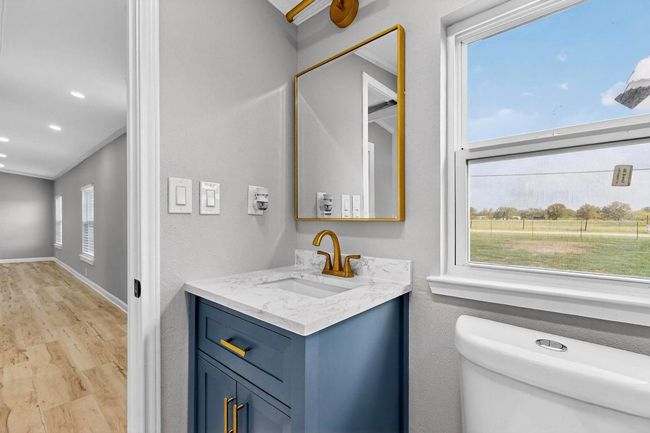 Bathroom with vanity, ornamental molding, toilet, wood finished floors, and baseboards | Image 21