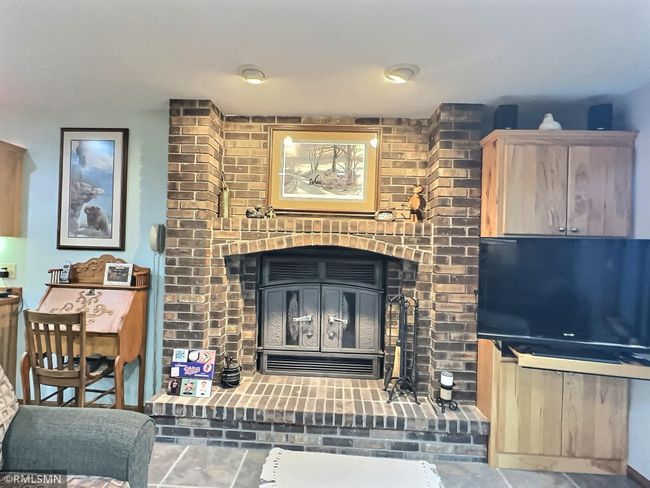 A close-up view of the fireplace and another built in oak cabinet. | Image 30