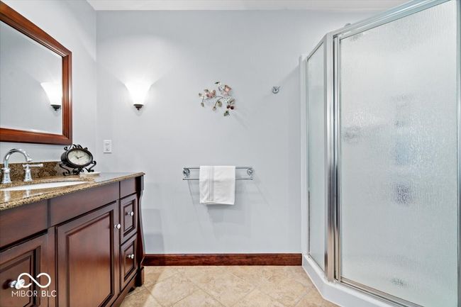 bathroom with a shower stall, vanity, and tile patterned flooring | Image 24