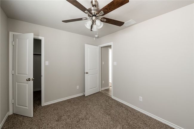 Unfurnished bedroom featuring visible vents, baseboards, carpet floors, and ceiling fan | Image 16