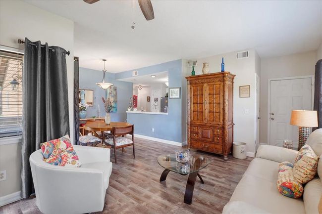 Living area featuring wood finished floors, a ceiling fan, and baseboards | Image 4