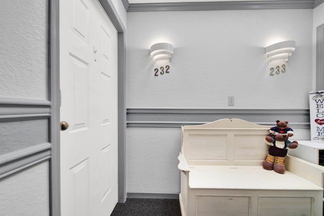 Clothes washing area with washing machine and dryer, laundry area, light colored carpet, and baseboards | Image 18