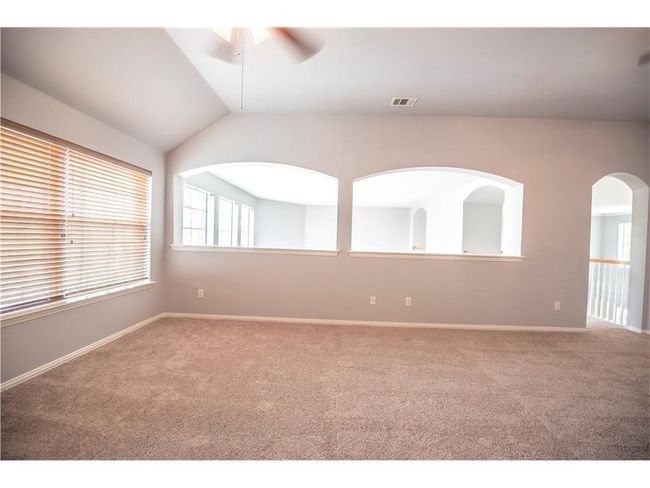 Carpeted spare room with ceiling fan, lofted ceiling, and baseboards | Image 10