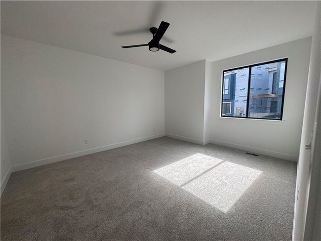 Carpeted empty room featuring baseboards, visible vents, and a ceiling fan | Image 12