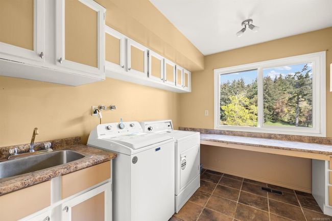 Laundry area featuring washer and dryer, cabinet space, and a desk | Image 19