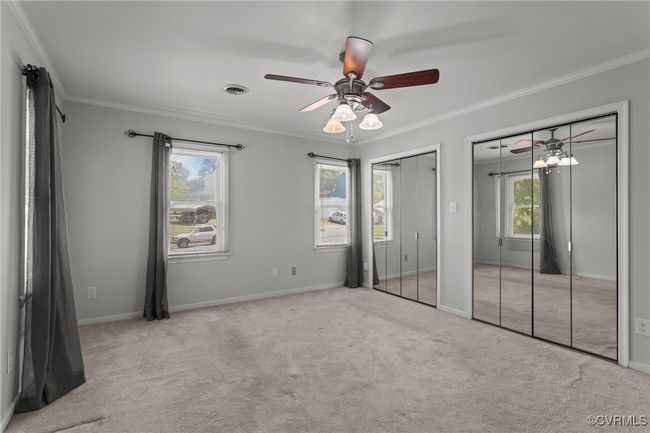 Unfurnished bedroom with two closets, visible vents, carpet flooring, and ornamental molding | Image 19