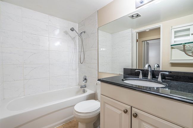 Bathroom with toilet, vanity, and bathtub / shower combination | Image 19