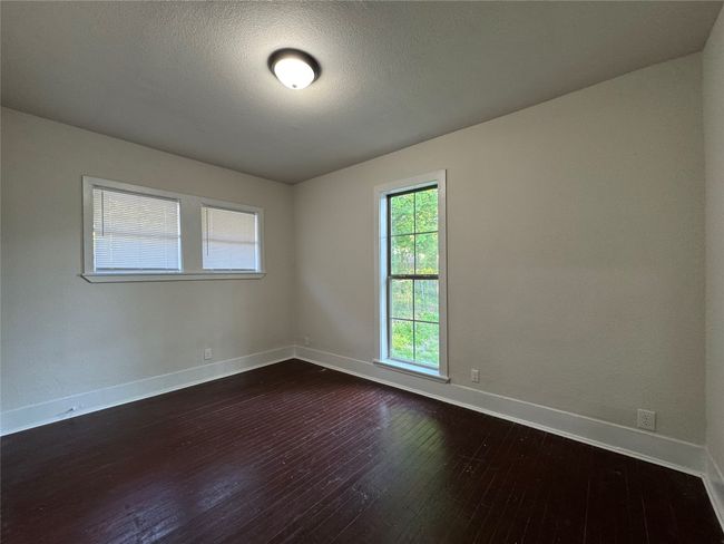 Empty room with dark wood-style floors and baseboards | Image 8