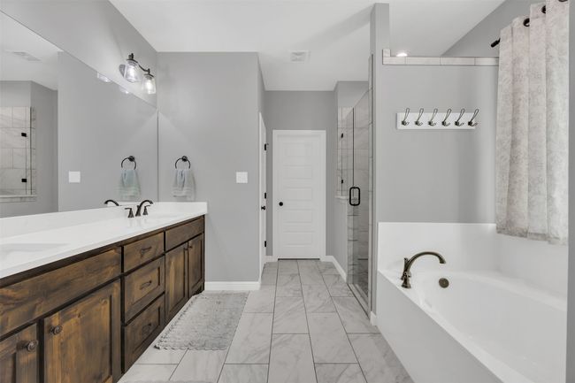 Full bathroom with visible vents, a garden tub, marble finish floor, a stall shower, and double vanity | Image 20