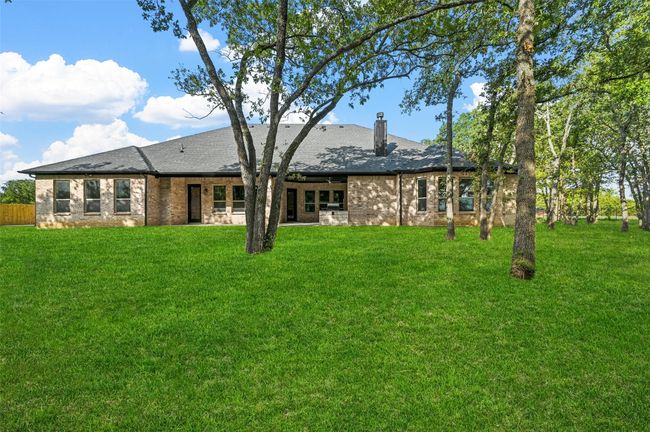 Rear view of property featuring brick siding, a lawn, and a chimney | Image 13