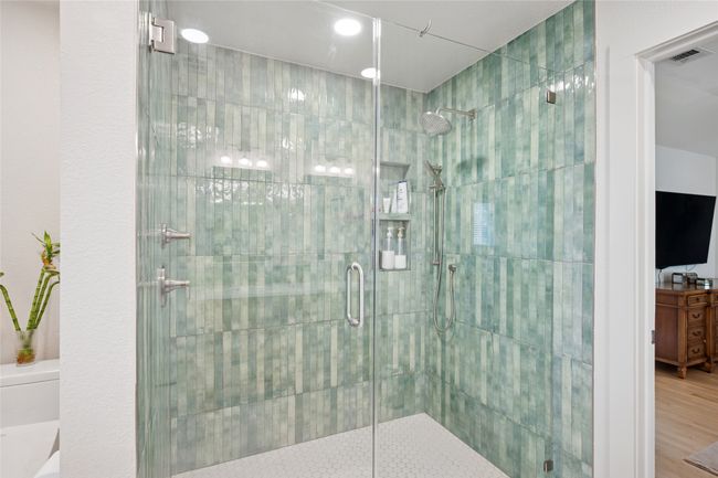 Verdant green tile shower surround with stainless fixtures. | Image 14