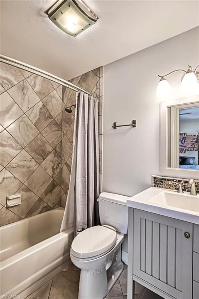 Bathroom featuring decorative backsplash, vanity, toilet, and shower / bath combination with curtain | Image 36