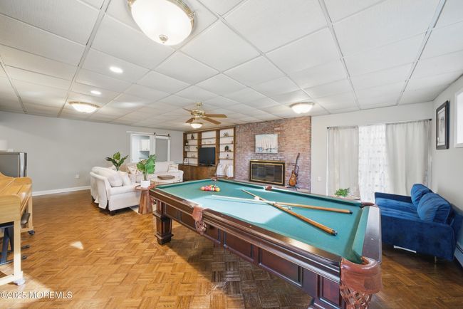 1st floor spacious living room with hw floors, fireplace, kitchenette nearby with sliders to level yard | Image 36
