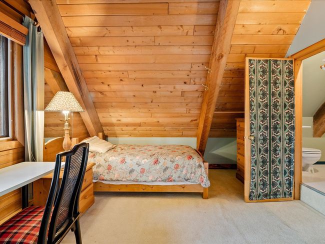 Carpeted bedroom with lofted ceiling, wooden ceiling, and wooden walls | Image 22