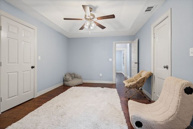 Sitting room featuring a raised ceiling, ceiling fan, and dark wood-style floors | Image 18