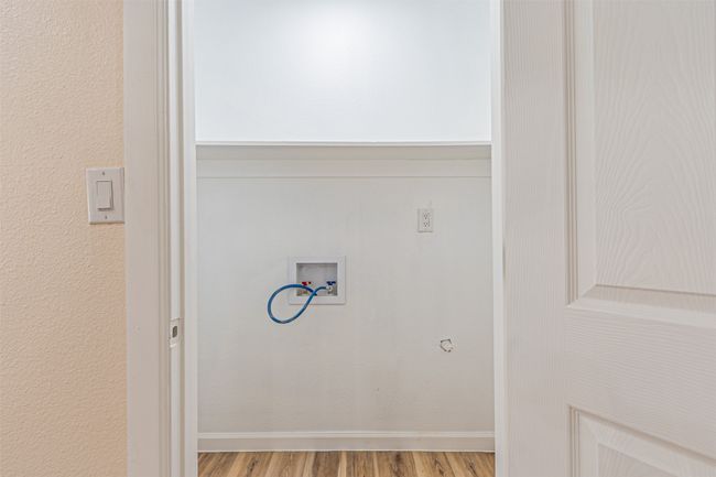 Washroom featuring washer hookup, wood finished floors, and laundry area | Image 12