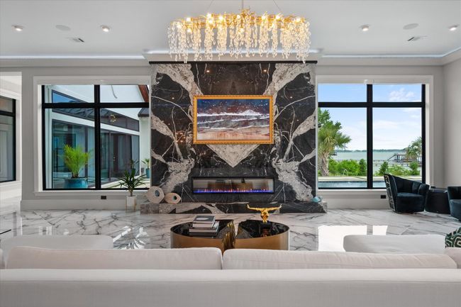 Living room featuring crown molding, a fireplace, a chandelier, marble finish floor, and recessed lighting | Image 7