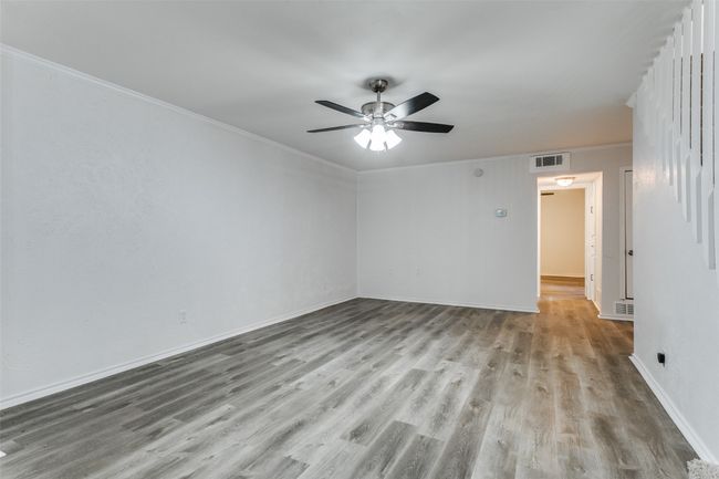 Spare room featuring ceiling fan, ornamental molding, wood finished floors, and visible vents | Image 14