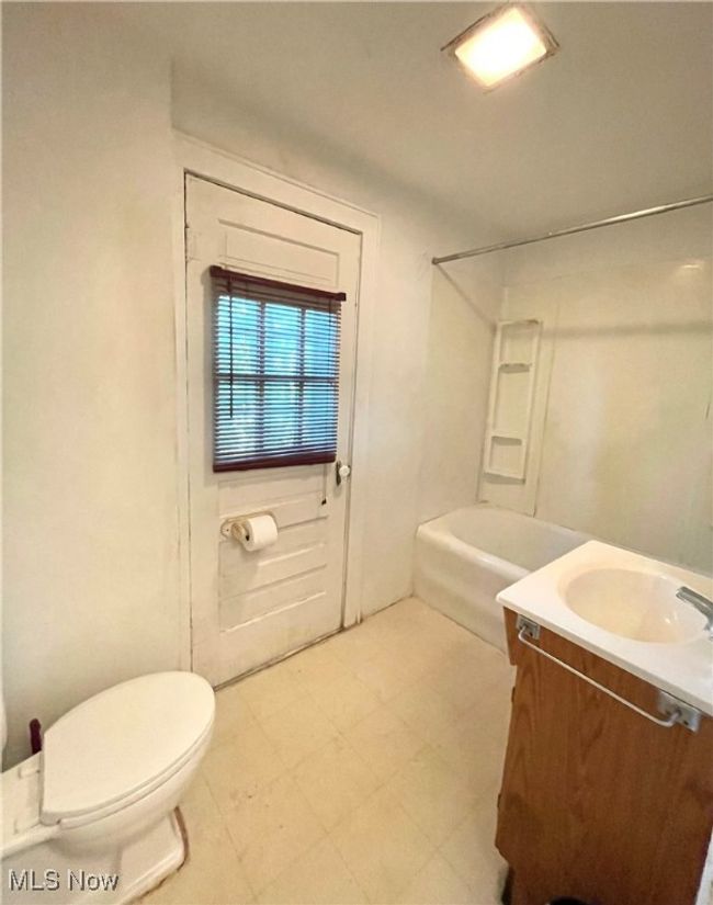 Full bathroom featuring tile patterned floors, toilet, vanity, and shower / bath combination | Image 17