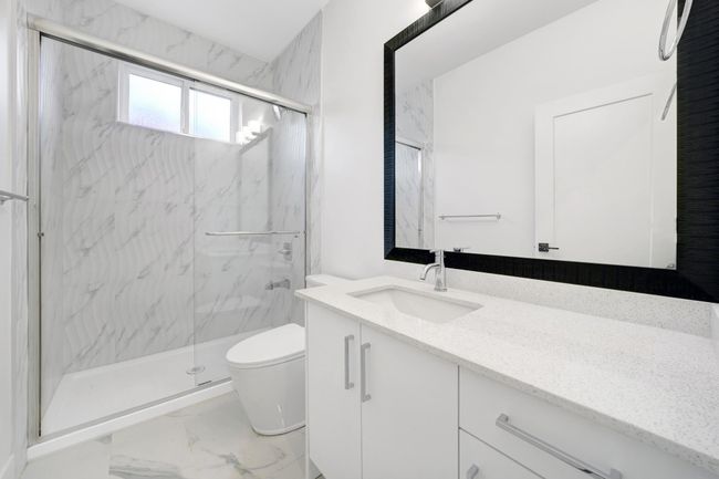 Full bath with toilet, a marble finish shower, vanity, and marble finish flooring | Image 22