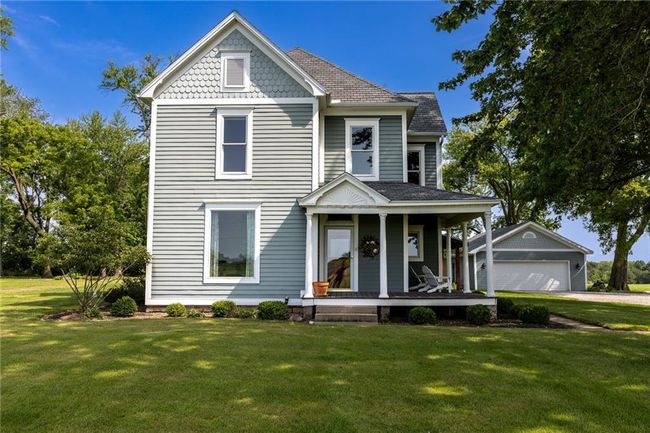 Victorian home featuring a garage, an outdoor structure, a front yard, and covered porch | Image 49