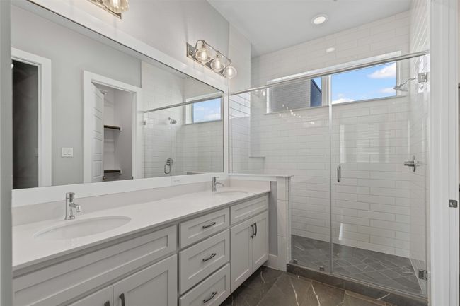 Full bath with a stall shower, marble look tiles, double vanity, and recessed lighting | Image 13