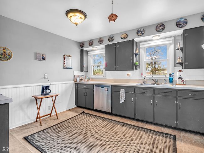 kitchen with gray cabinetry, open shelves, dishwasher, and a sink | Image 16