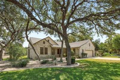 Mature Texas Live Oak trees provide shade and add curb appeal on this all sides brick home by Del Webb. | Image 1