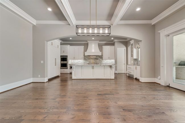 Kitchen featuring crown molding, arched walkways, and premium range hood | Image 10