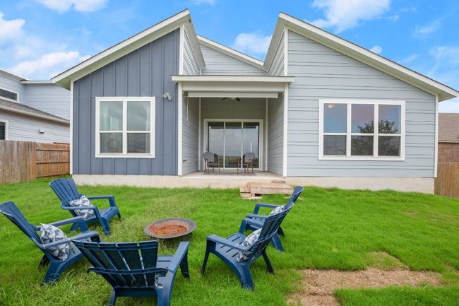 Rear view of property featuring board and batten siding, an outdoor fire pit, and a patio | Image 24