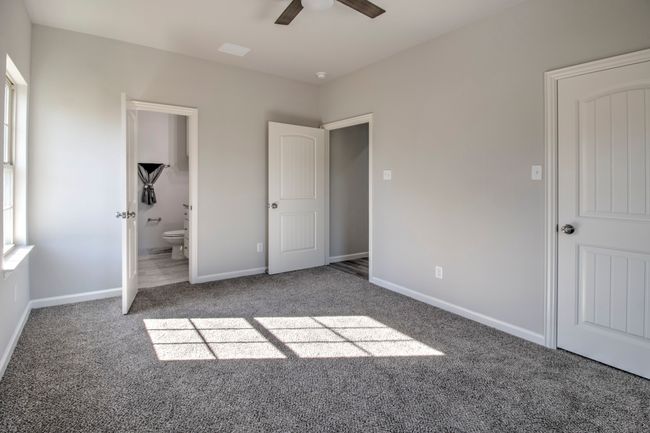 Unfurnished bedroom featuring carpet flooring, ensuite bath, and ceiling fan | Image 16