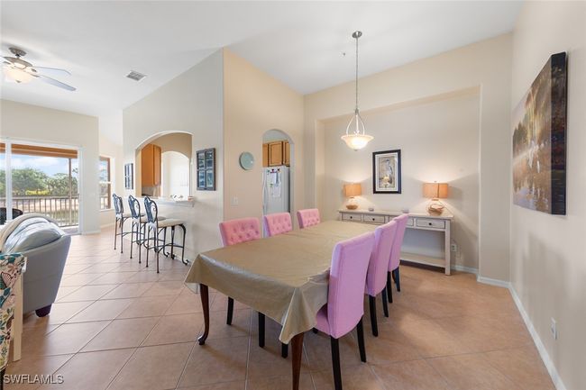 Dining area with ceiling fan, arched walkways, visible vents, and light tile patterned floors | Image 13