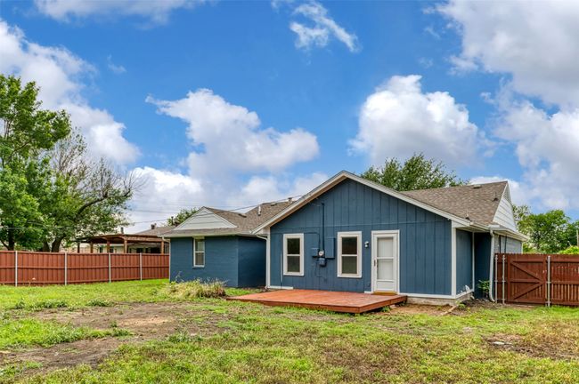 Rear view of property with a deck, a shingled roof, and board and batten siding | Image 26
