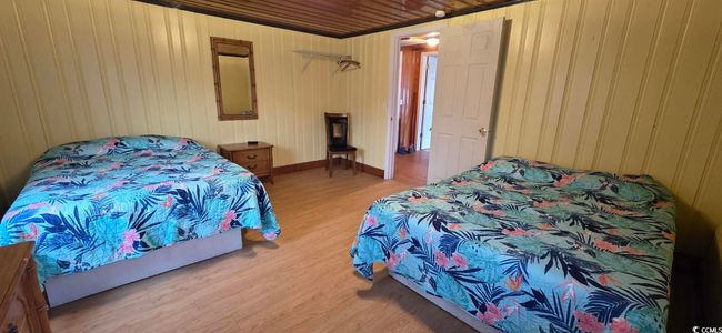 Bedroom featuring light wood finished floors and wood walls | Image 25