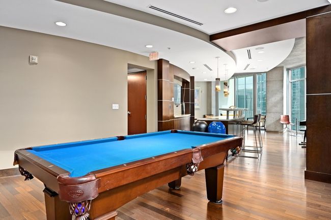 Recreation room with pool table, wood finished floors, a wall of windows, and recessed lighting | Image 26
