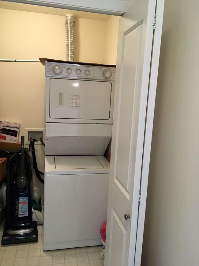 Laundry room with stacked washer / drying machine and laundry area | Image 12