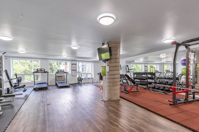 Workout area featuring decorative columns and wood finished floors | Image 39