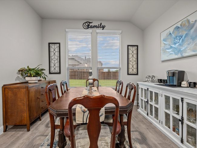 Dining room featuring light wood-style flooring and vaulted ceiling | Image 10