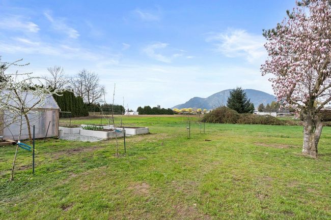 View of yard featuring a rural view, a garden, a mountain view, and an outbuilding | Image 5