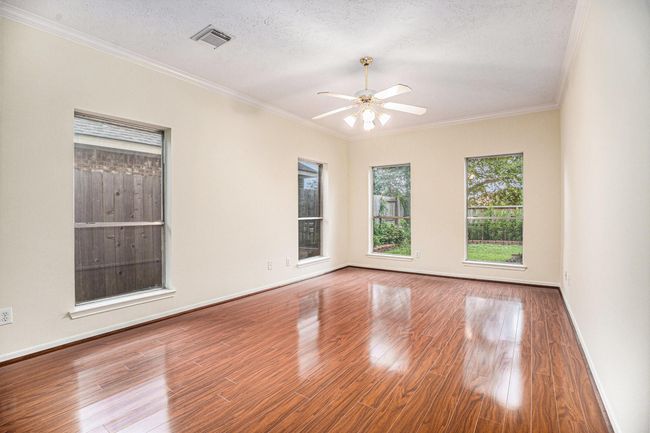 Downstairs primary suite with Luxury Vinyl Plank flooring and ceiling fan. | Image 21