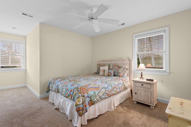 Bedroom with light colored carpet, baseboards, and a ceiling fan | Image 18
