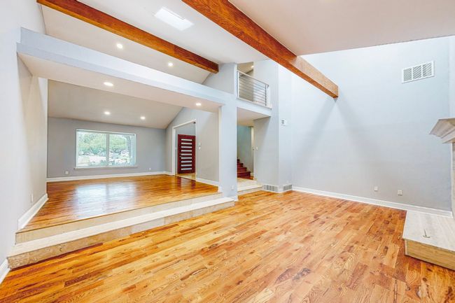 Living area, wood floors, vaulted ceiling with beams. Step down from the living area to the family room | Image 4