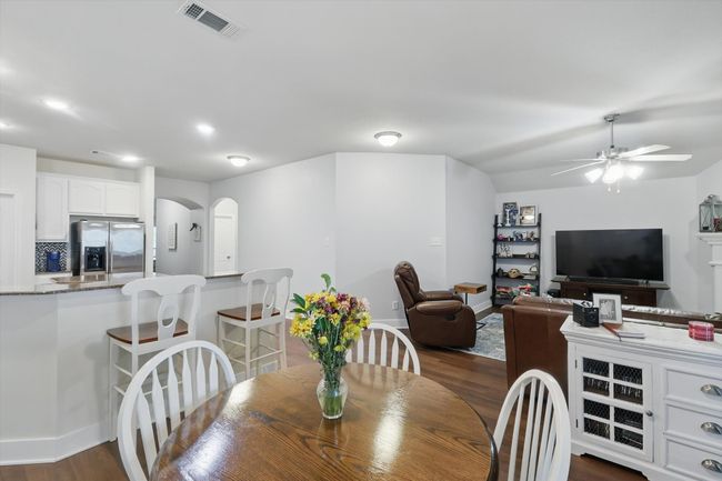 Dining space featuring dark wood-style flooring, ceiling fan, arched walkways, and recessed lighting | Image 18