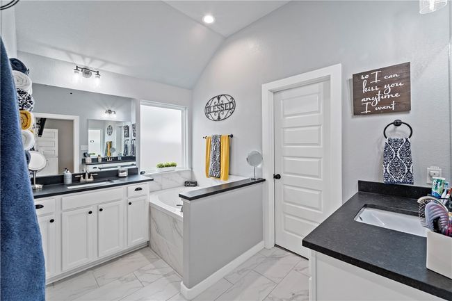 Bathroom with marble finish floor, a sink, and lofted ceiling | Image 5