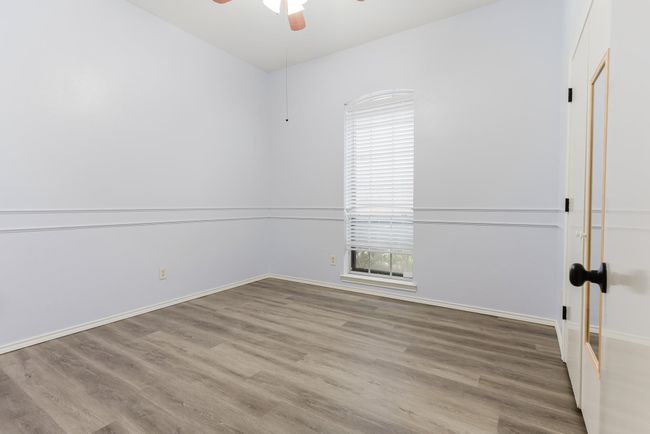Spare room featuring baseboards, wood finished floors, and a ceiling fan | Image 18