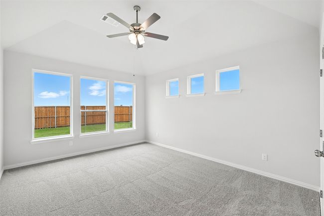 Carpeted spare room featuring lofted ceiling, ceiling fan, and plenty of natural light | Image 15